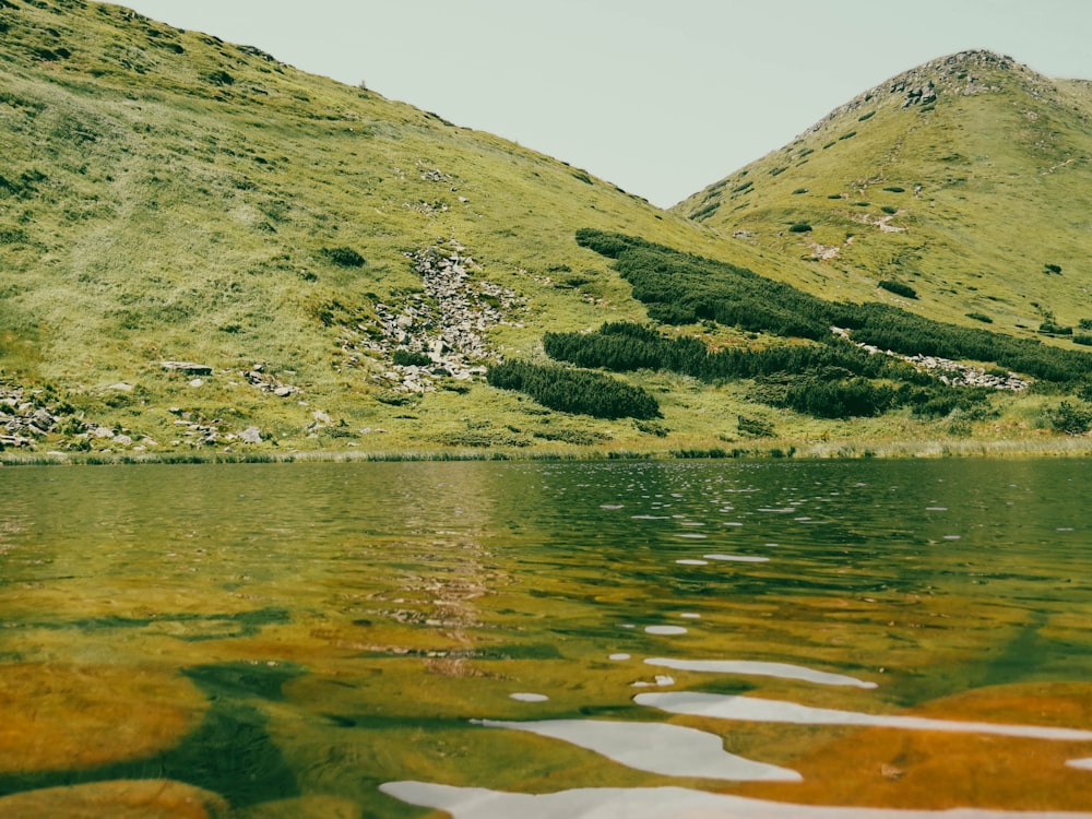 a body of water with hills in the back