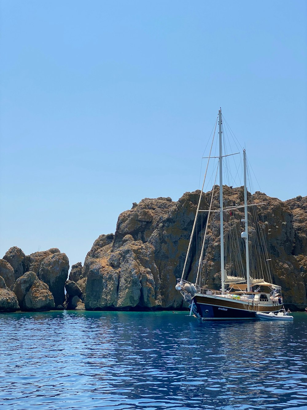 a boat in the water by a rocky cliff