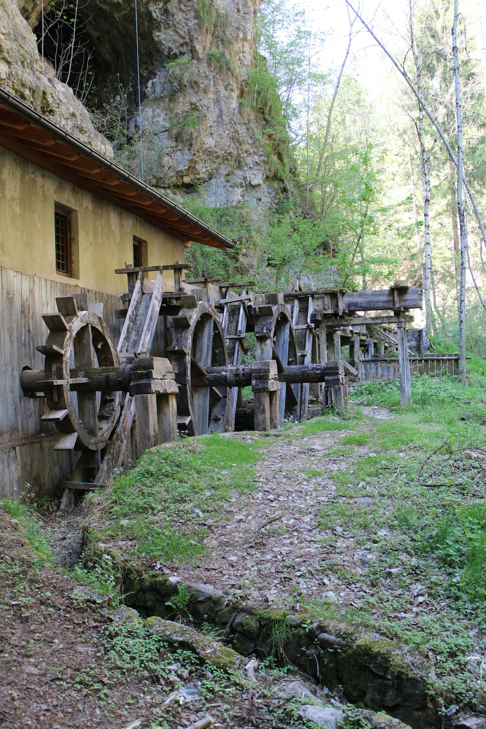 a wooden building with a wheelbarrow in front of it