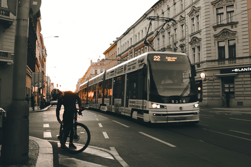 a person riding a bicycle next to a bus on a street
