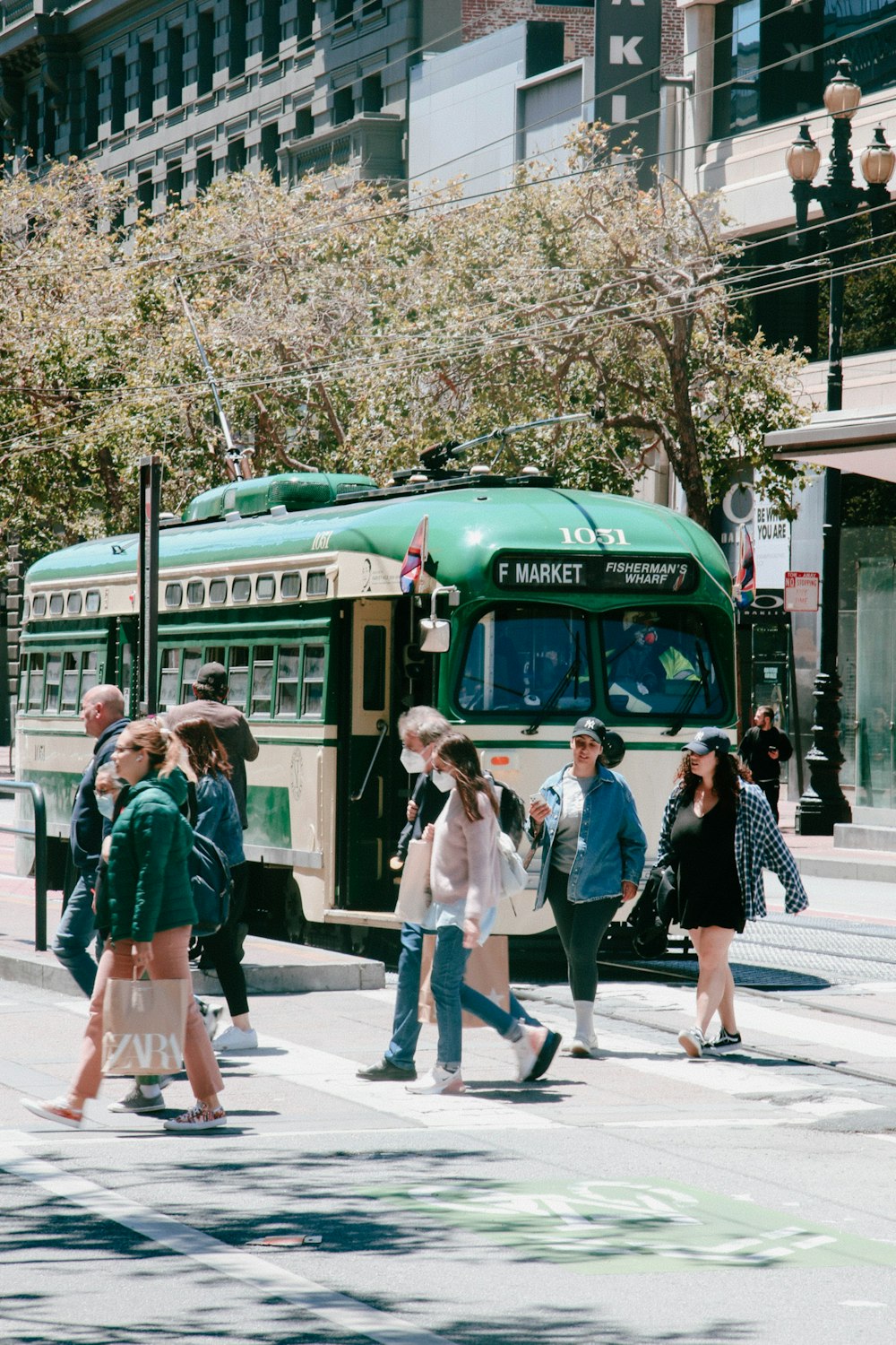 a group of people walking on a street next to a bus