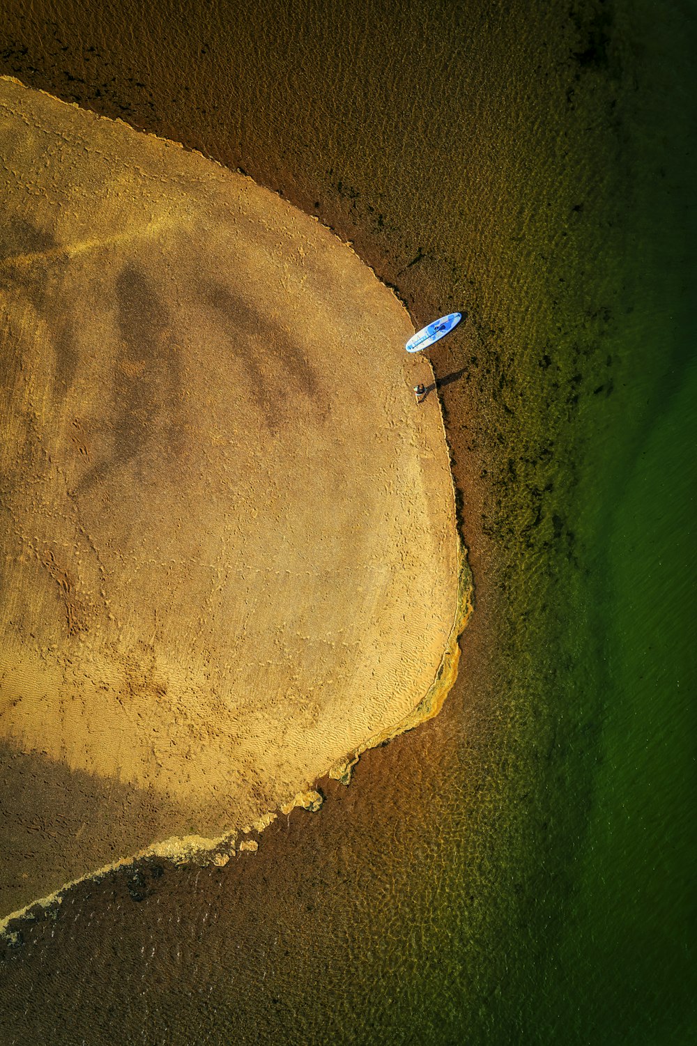 a blue and white balloon floating in the air above a field of grass