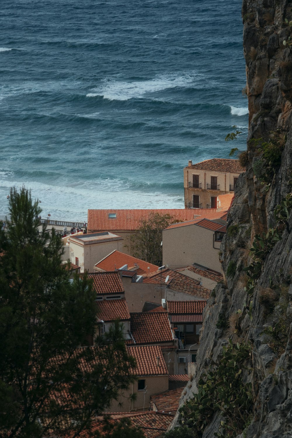 a town by the water with Casa Malaparte in the background