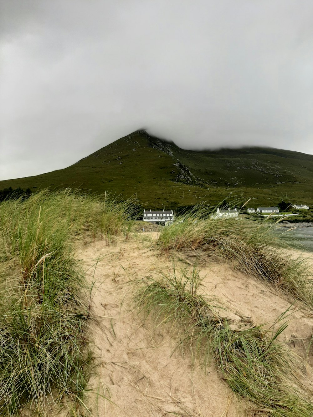 a sandy beach with a hill in the background