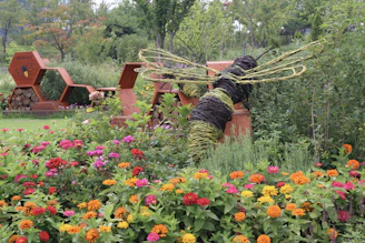 a garden with flowers and a statue