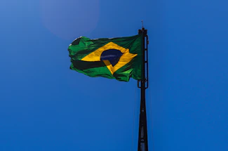 Official flag of the state of Bahia waving gently against a clear blue sky.
