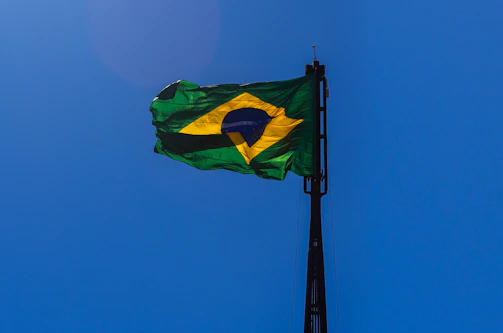 Official flag of the state of Bahia waving gently against a clear blue sky.