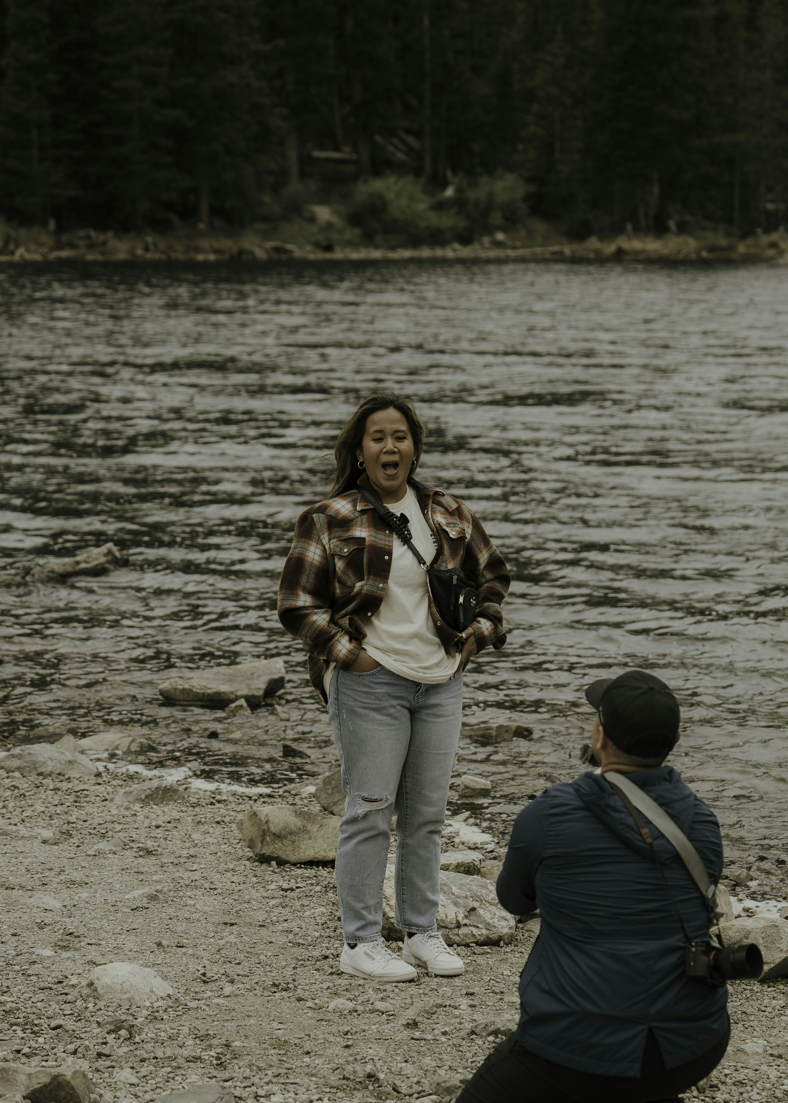Fotomural a woman holding a camera and a man standing on a beach
