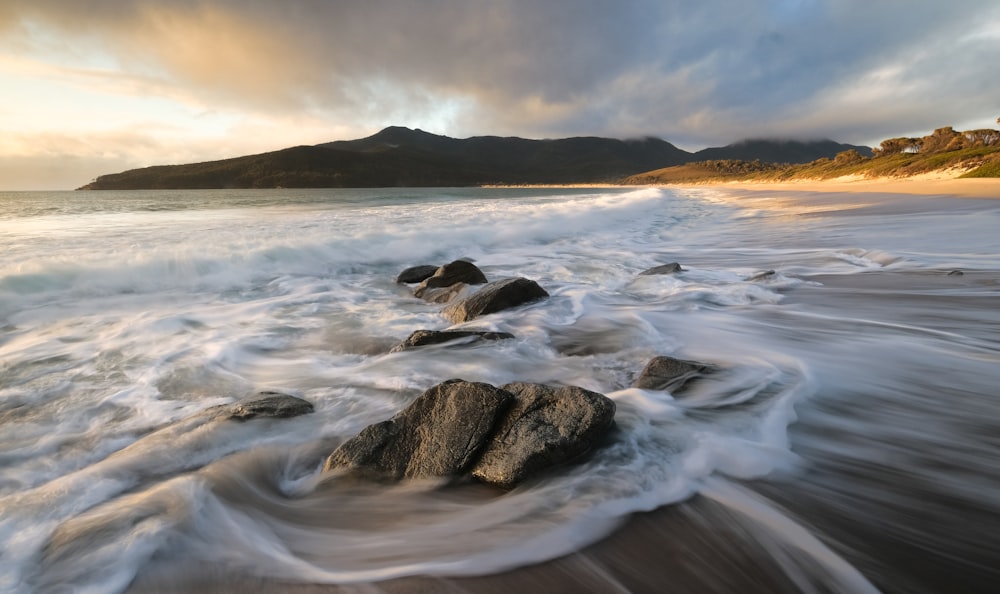 a rocky beach with waves crashing on it