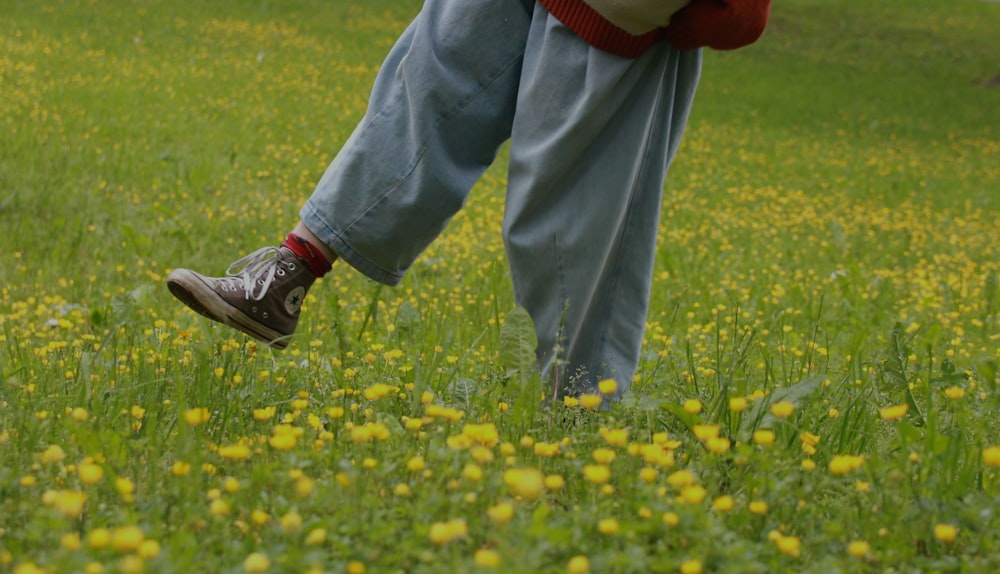 a person's legs in a field of yellow flowers