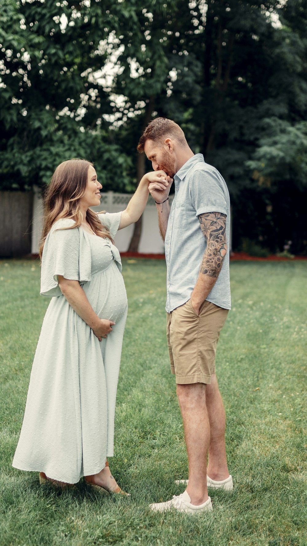 a man and woman standing in a grass field