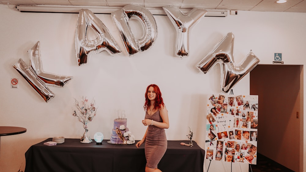 a person standing in front of a table with a vase of flowers