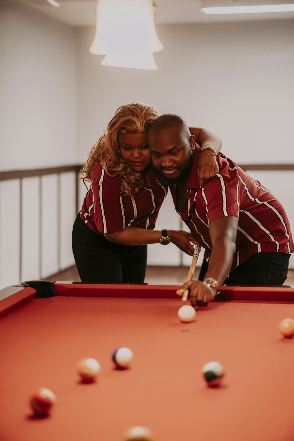 a man and a woman playing pool
