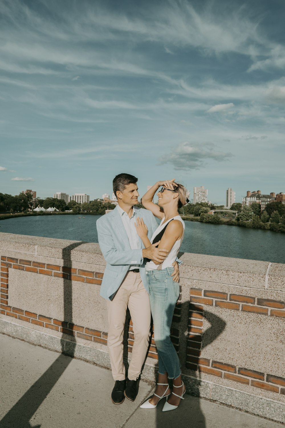 um homem e uma mulher se beijando em uma ponte sobre a água