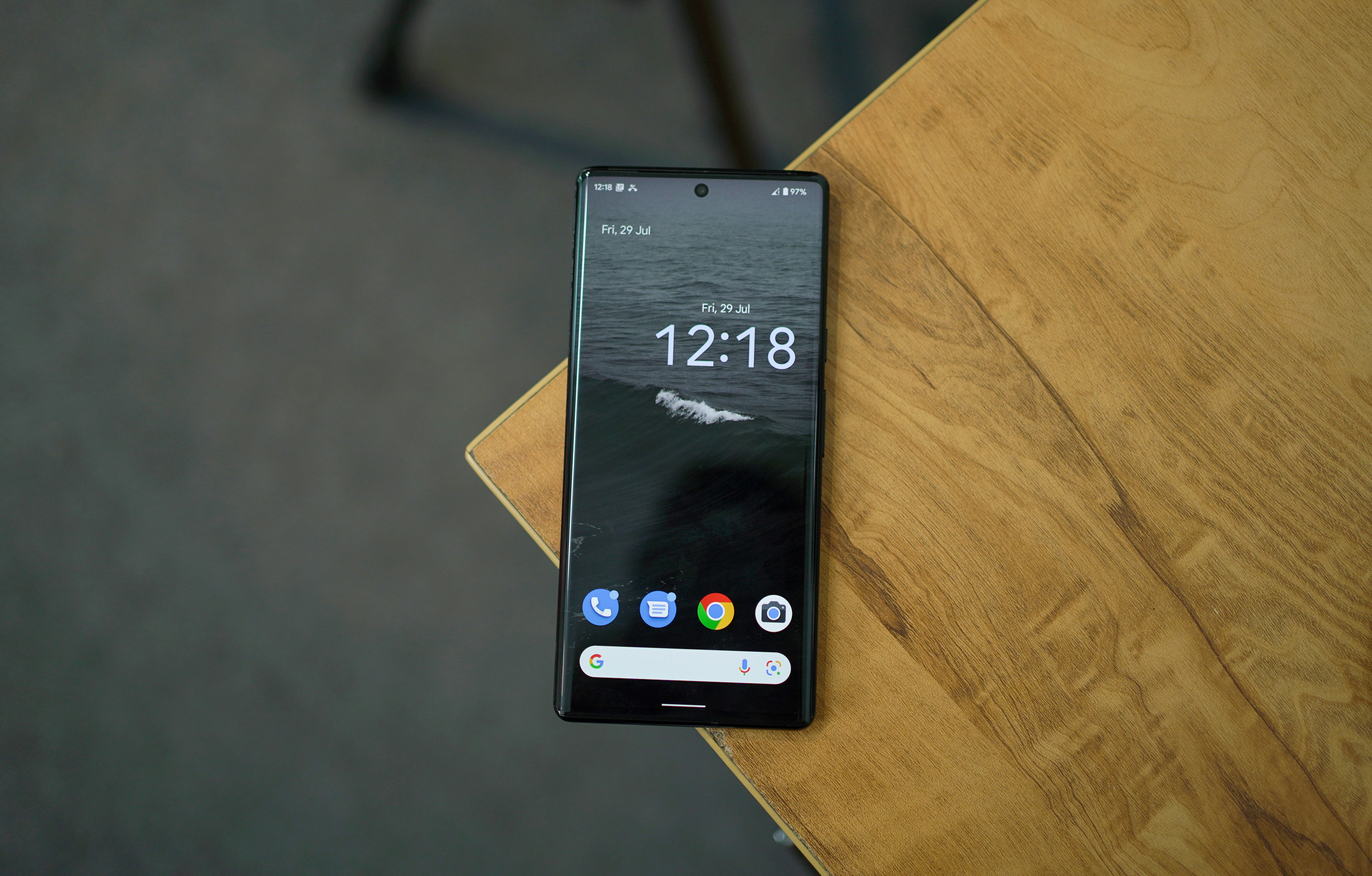 a black cell phone on a wooden surface