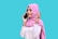 A smiling person wearing a pink hijab and white shirt holds a smartphone to their ear against a solid turquoise background. The individual appears to be engaged in a phone conversation, with a cheerful expression and an animated pose.