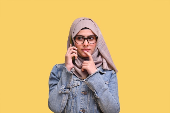 a person wearing a hoodie and holding the hands to the face