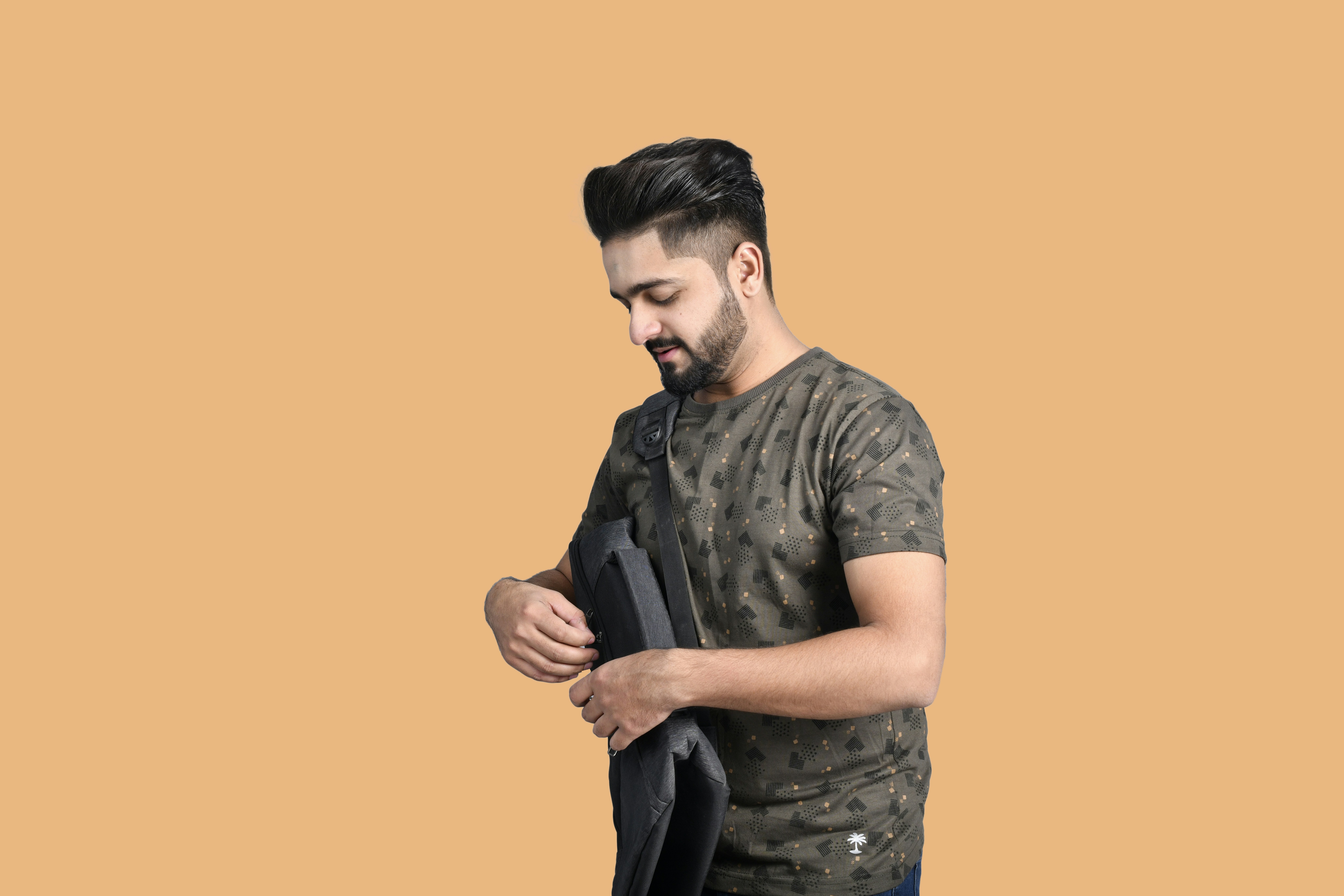 a man with a beard and a black shirt with a black bag