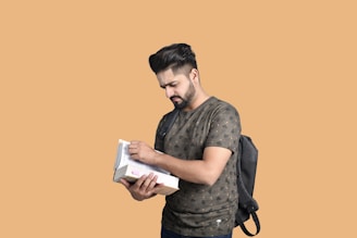 Close-up of a fitted t-shirt with a bold, clean design, worn by a man studying outdoors with books nearby.