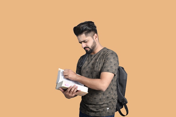 Close-up of a fitted t-shirt with a bold, clean design, worn by a man studying outdoors with books nearby.