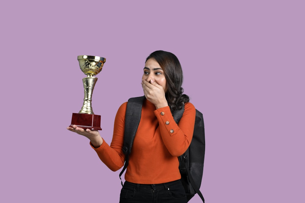 a woman holding a trophy