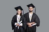 a man and woman wearing graduation gowns and caps