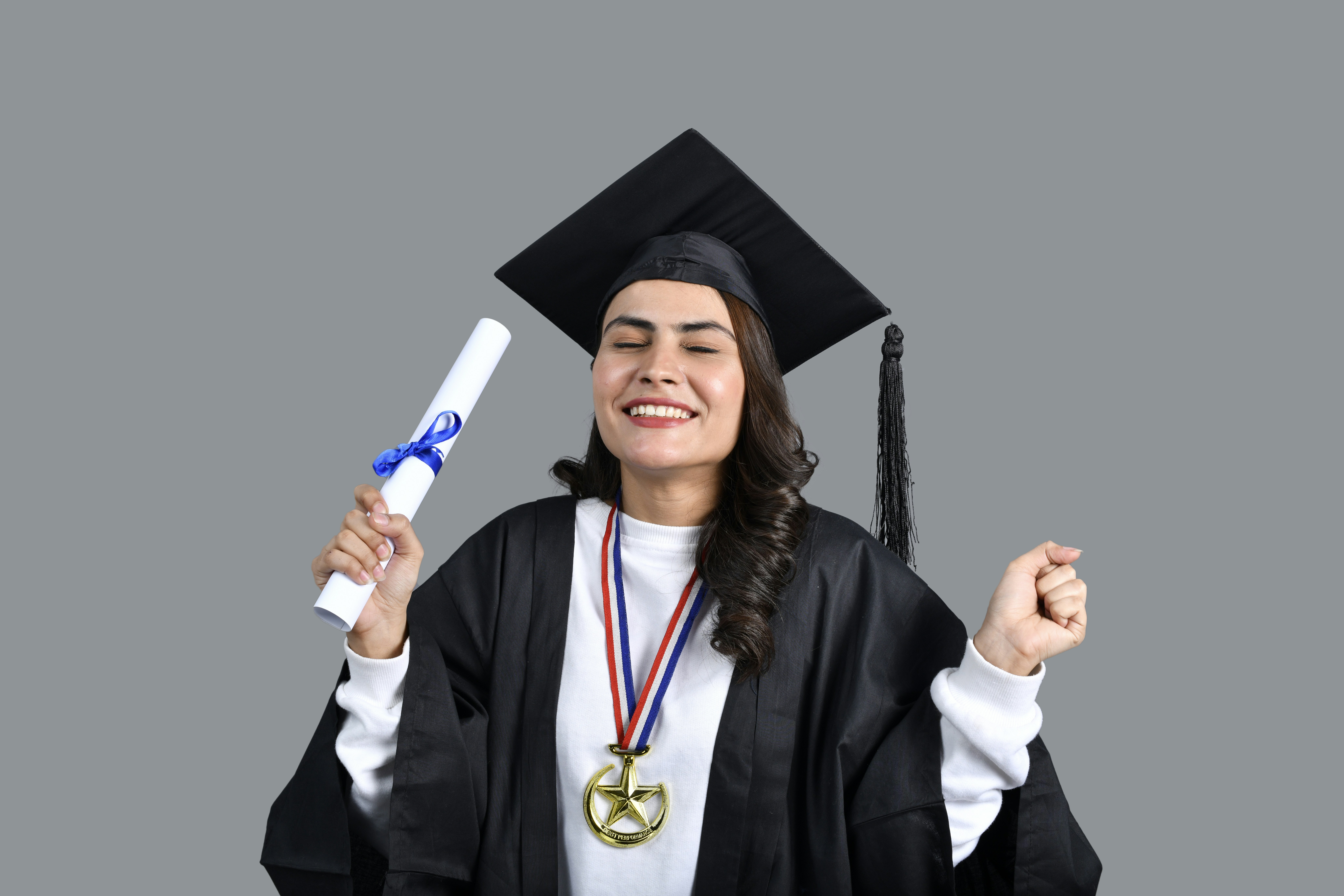 a man wearing a graduation cap and gown holding a diploma