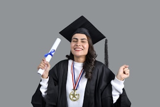 a man wearing a graduation cap and gown holding a diploma