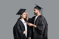 a man and woman wearing graduation gowns and caps