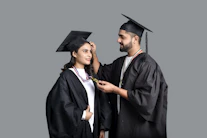a man and woman wearing graduation gowns and caps