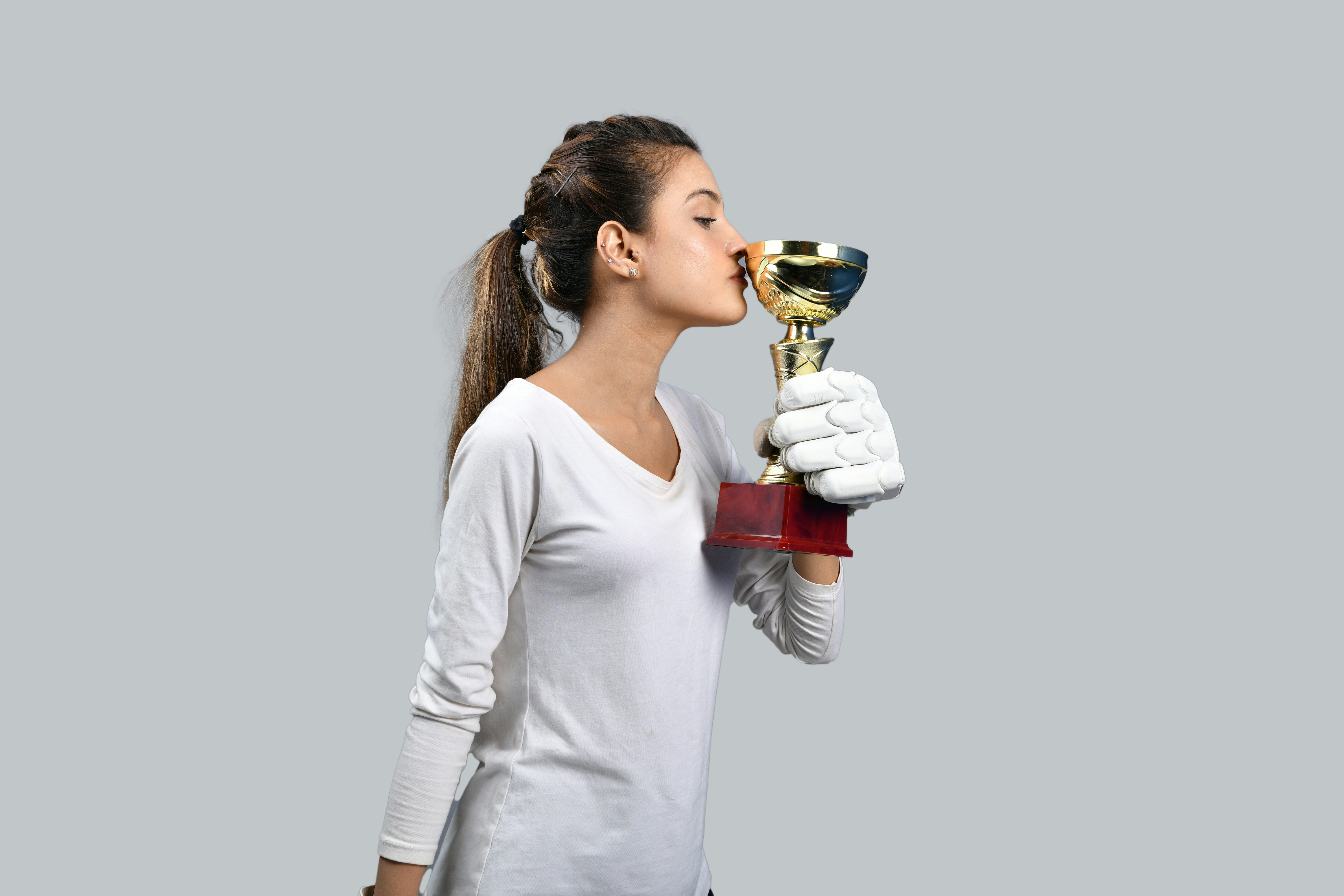 a woman wearing a white lab coat and gloves holding a trophy