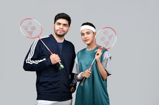 a man and a woman holding tennis rackets
