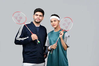 a man and a woman holding tennis rackets
