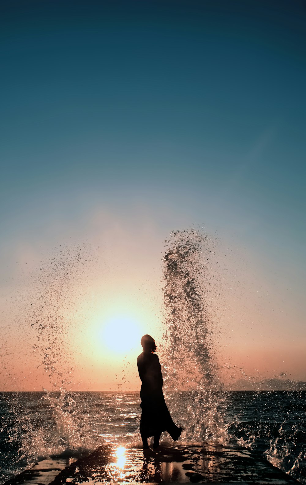 a person standing in front of a large explosion