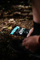 Close-up of hands tying running shoes on a park trail.