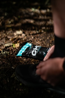 Runner tying shoelaces on a trail at sunrise