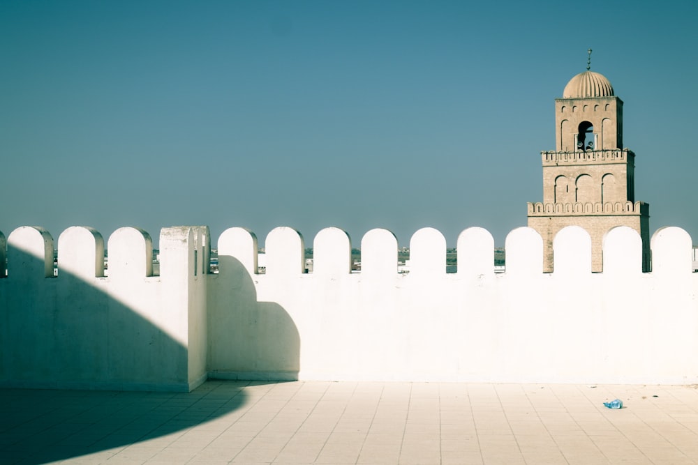 a white wall with a tower