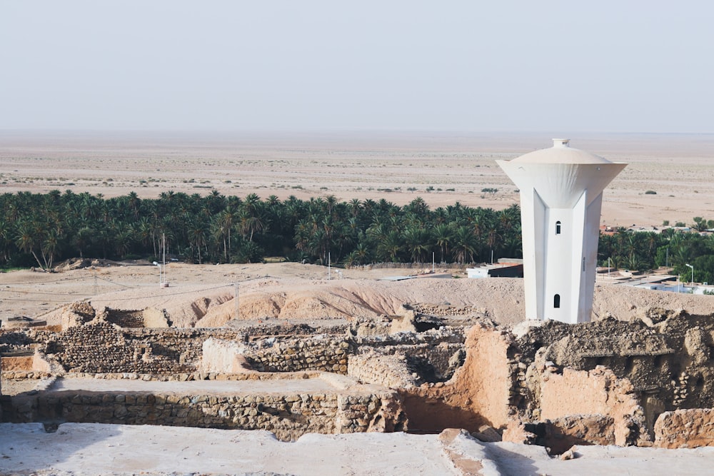 a white tower on a rocky hill