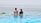 A couple relaxing by the infinity pool with the Adriatic Sea in the background.