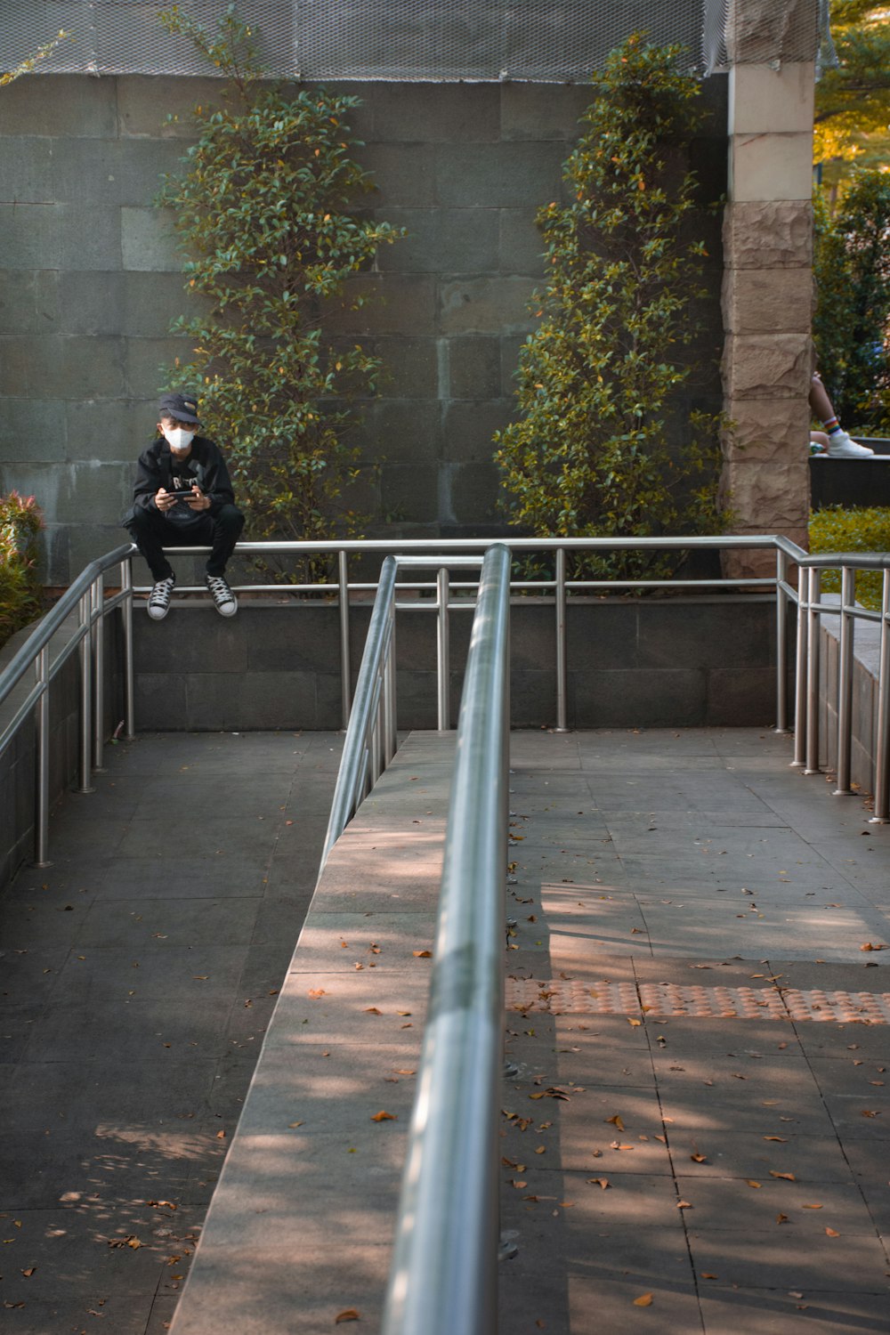 une personne assise sur une balustrade métallique