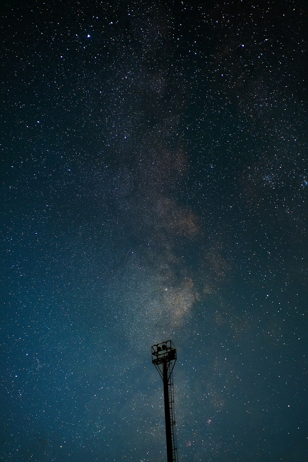 a pole with a light on it and stars in the sky