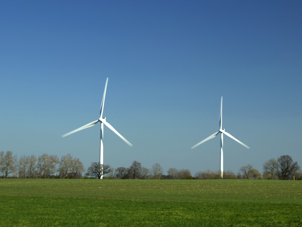 a group of white windmills in a field