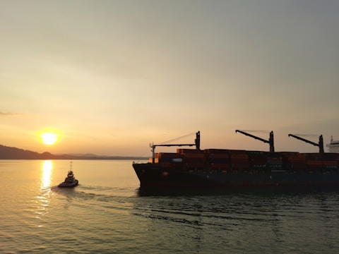 Oil tanker ship navigating calm ocean waters at sunset