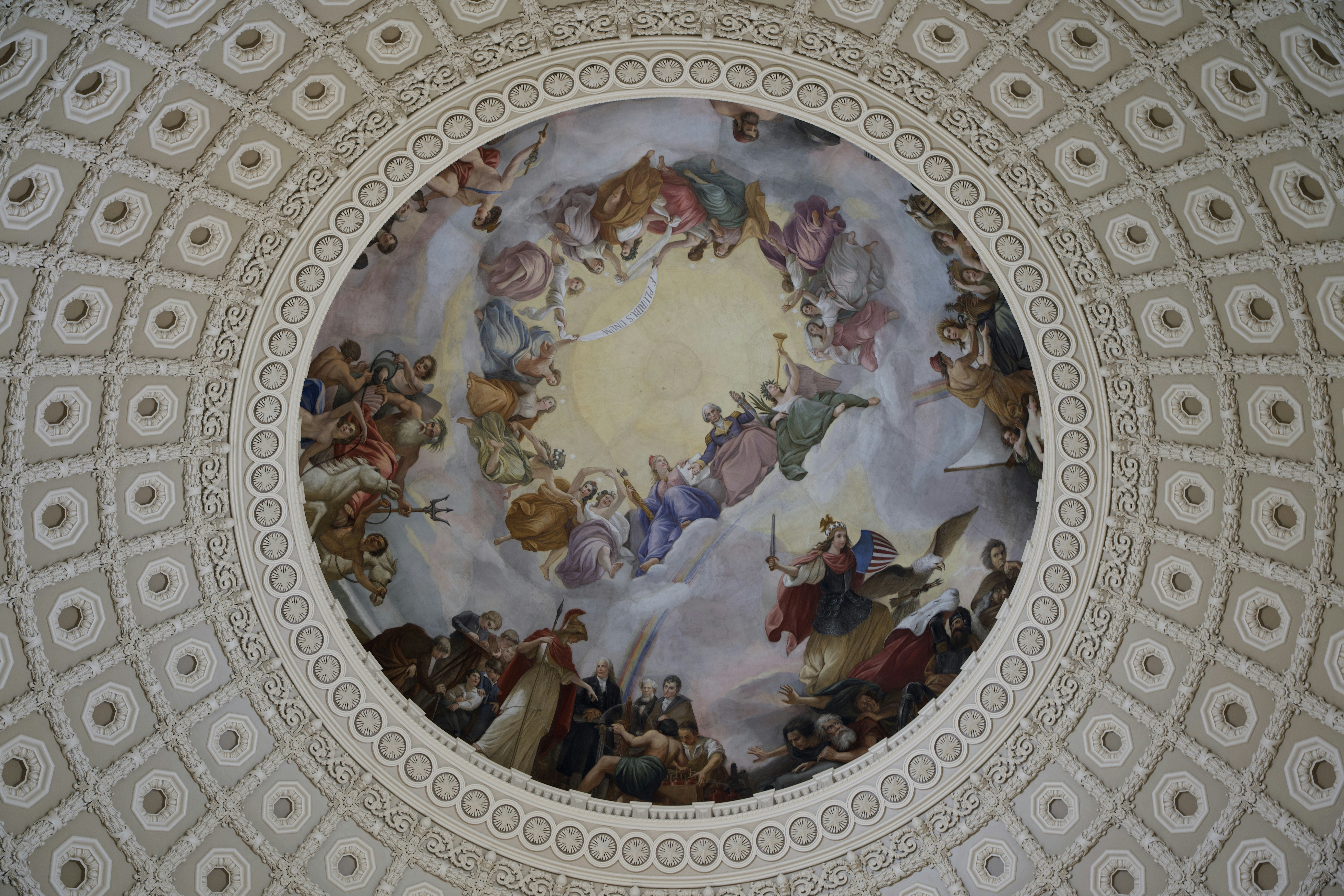 a circular gold plate with a painting on it