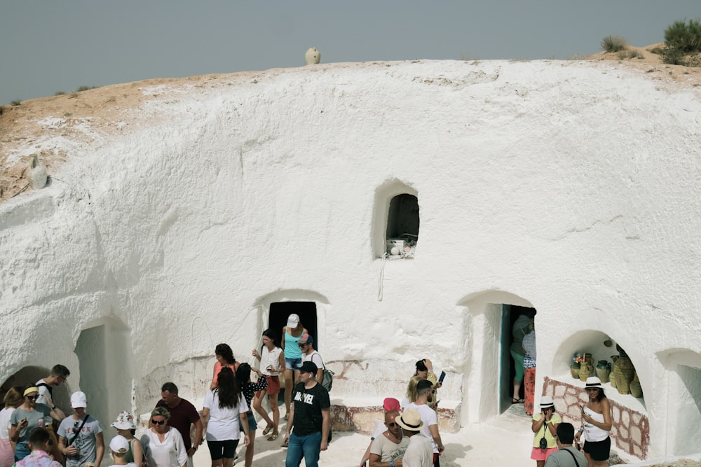 a group of people walking through a large white building