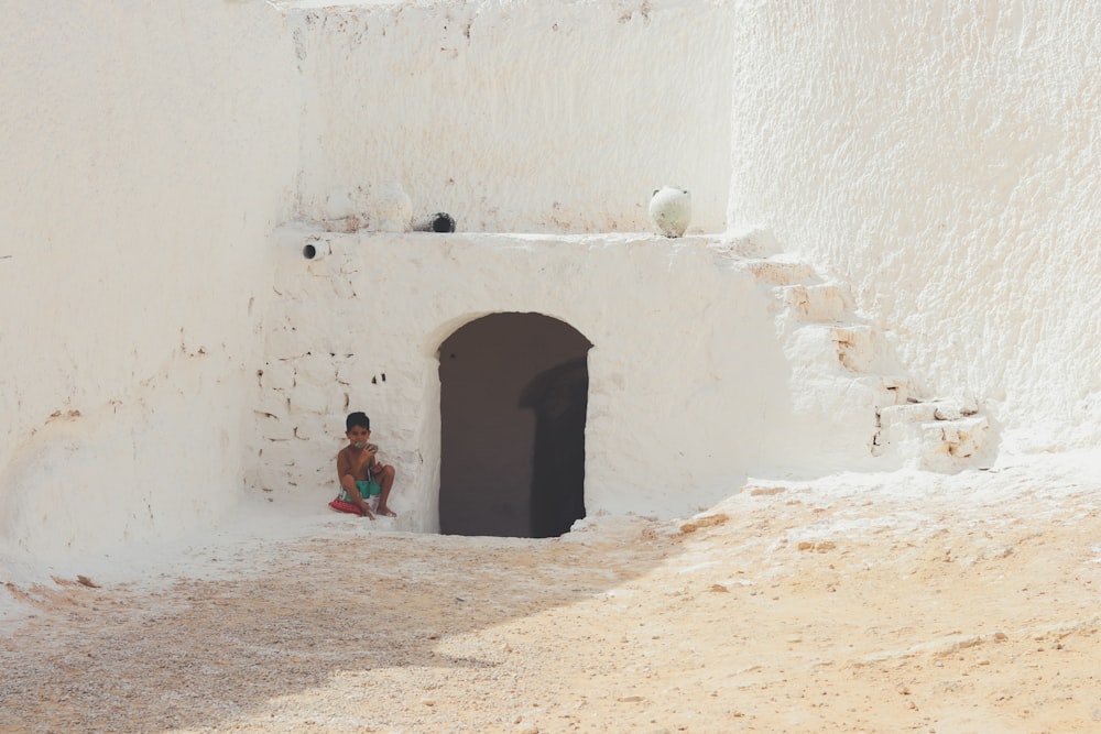 a boy sitting in a doorway