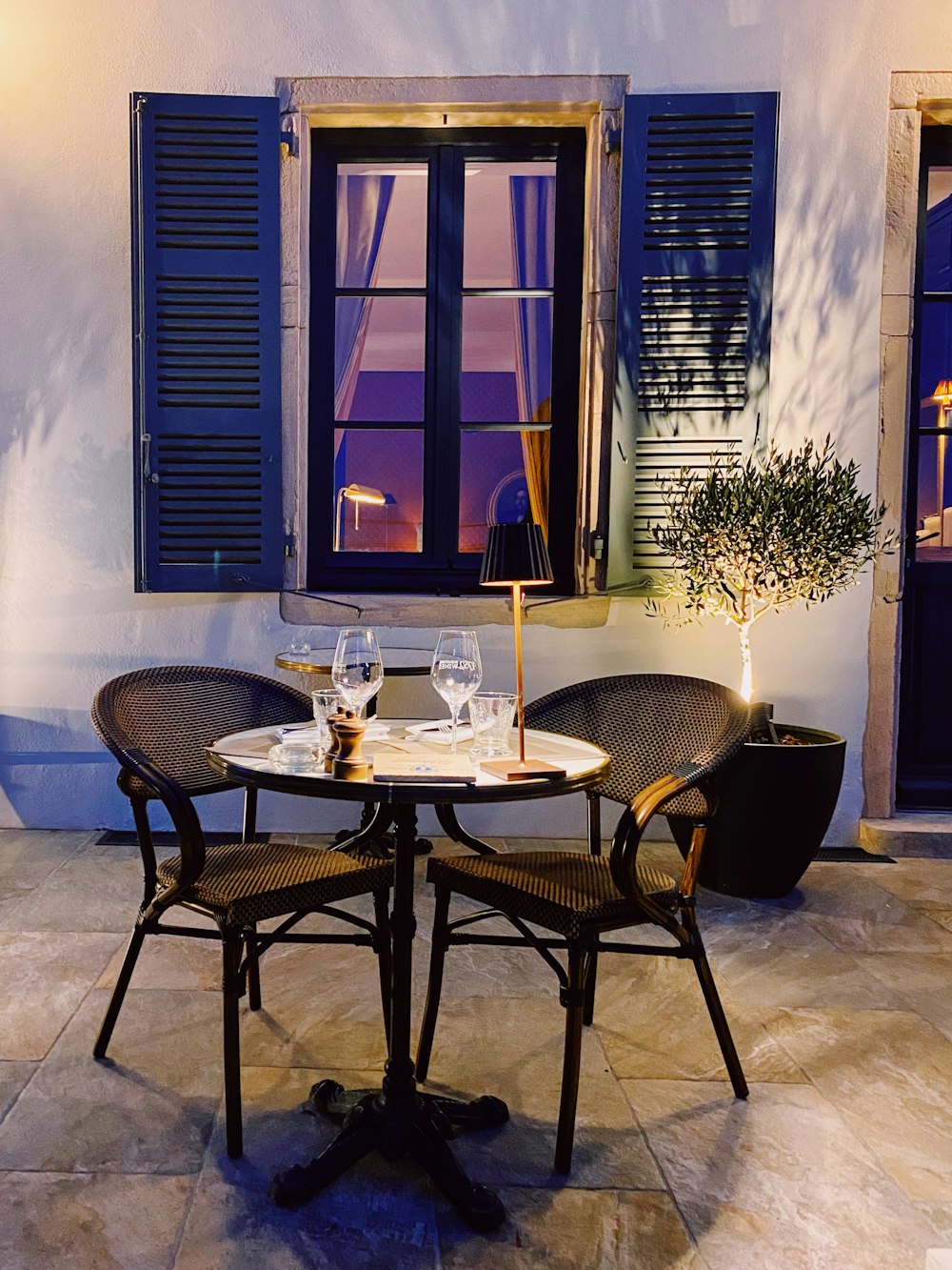 a table with chairs and glasses on it