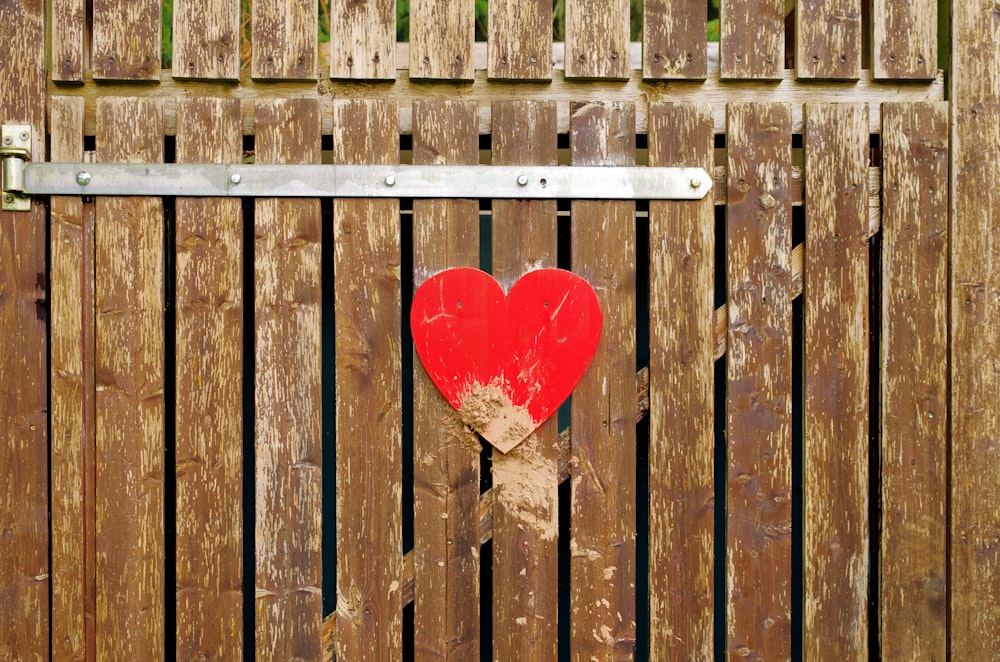 a close up of a brown wooden bench sitting next to a fence