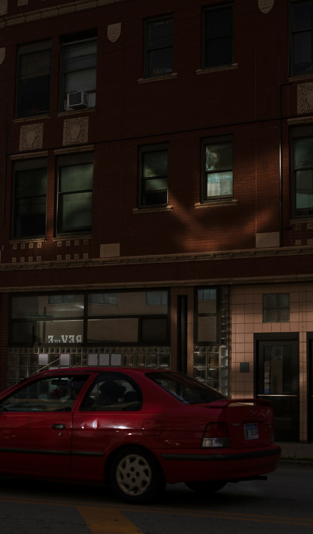 a red car parked in front of a building