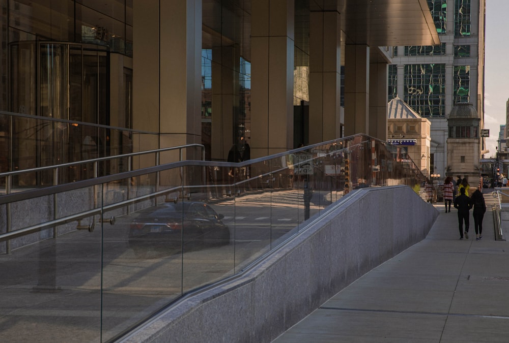 a group of people walking on a sidewalk next to a building